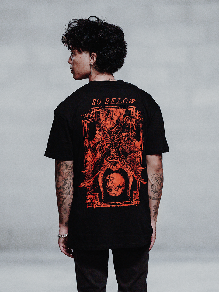 A model wearing a black cotton tee with custom Blackcraft artwork on the front and back.