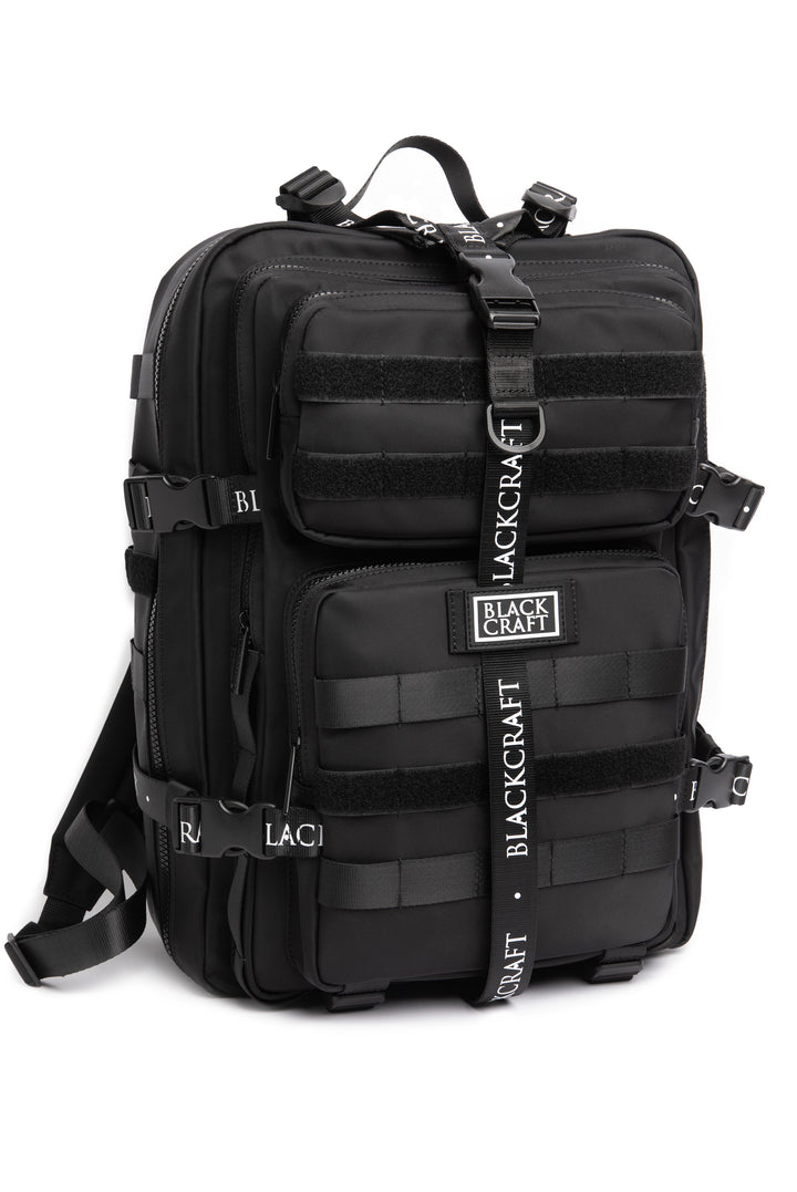 Large black nylon backpack with Blackcraft rubber logo, functional buckles, and logo strap details.