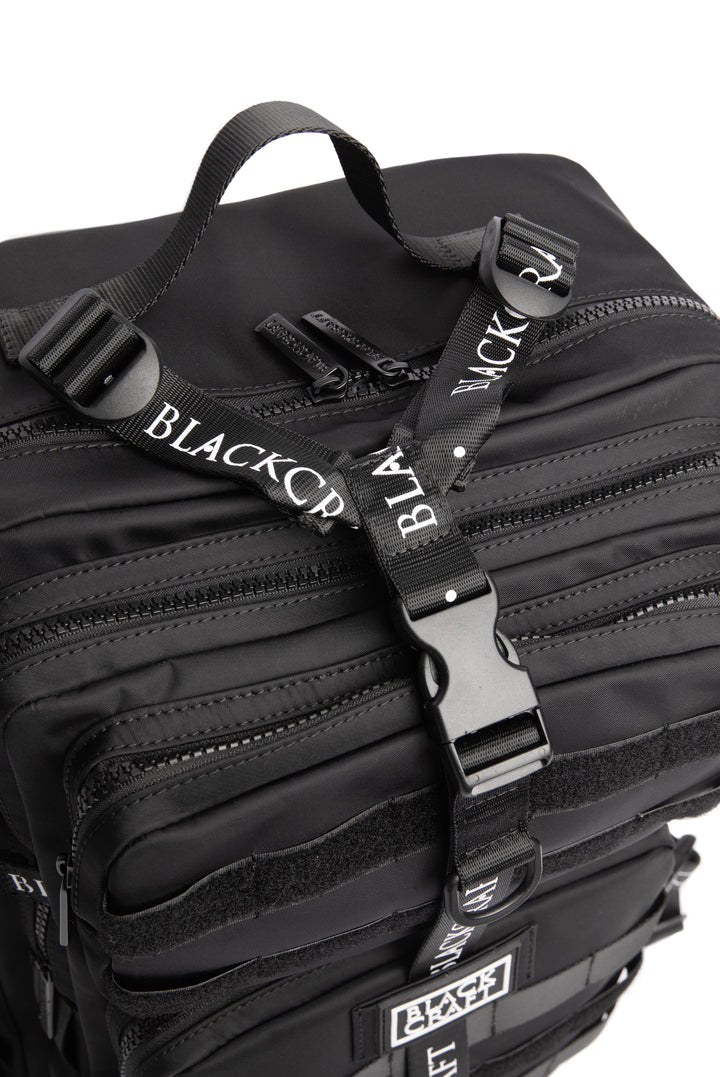 Large black nylon backpack with Blackcraft rubber logo, functional buckles, and logo strap details.