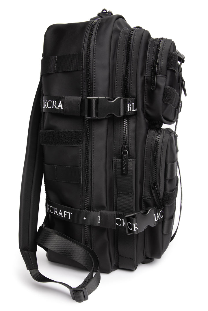 Large black nylon backpack with Blackcraft rubber logo, functional buckles, and logo strap details.