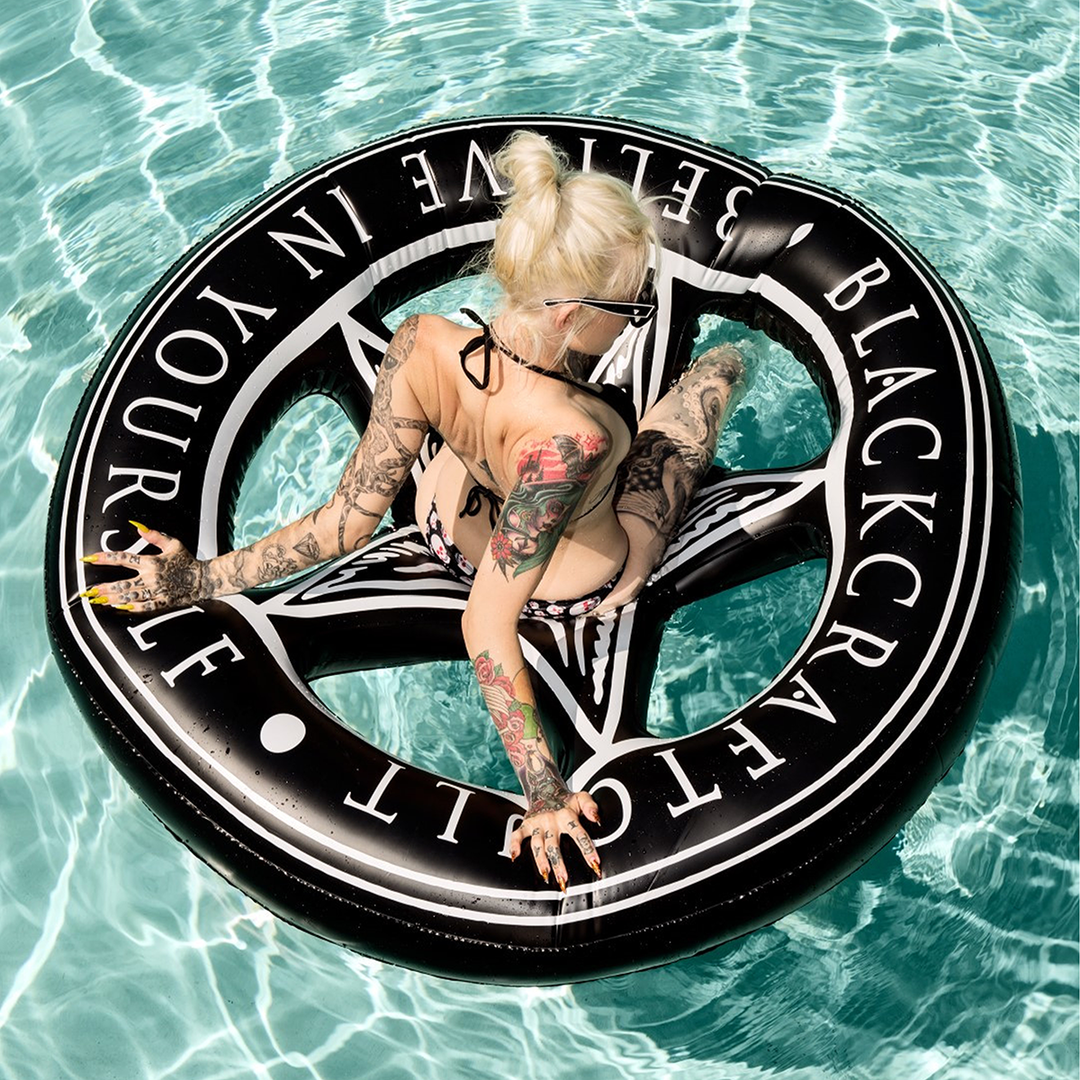 A black inflatable circular pool float with pentagram interior and custom blackcraft artwork. 