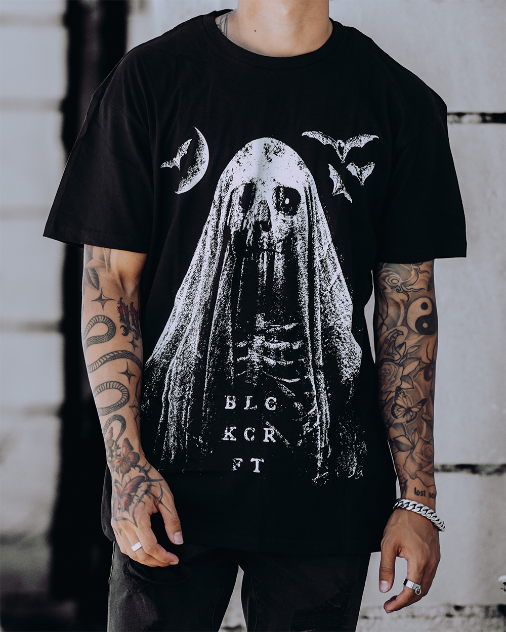 A model wearing a classic black cotton tee with custom Blackcraft artwork across the front. 