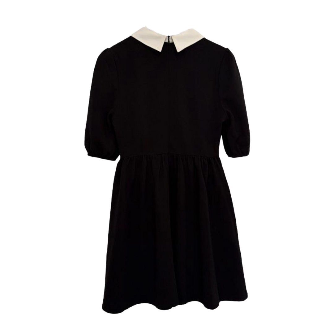 Black dress with a white collar on a white background