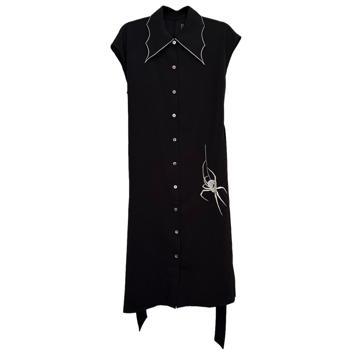 A classic black shirt dress with a spider web inspired collar with contrast white trim, an embroidered spider detail, a button front, short sleeves, and an adjustable waist tie. 