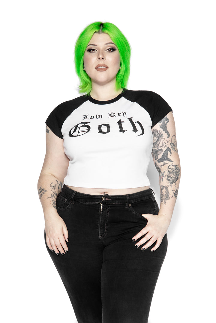 A stretchy raglan tee in white and black with Low Key Goth artwork on the front. 
