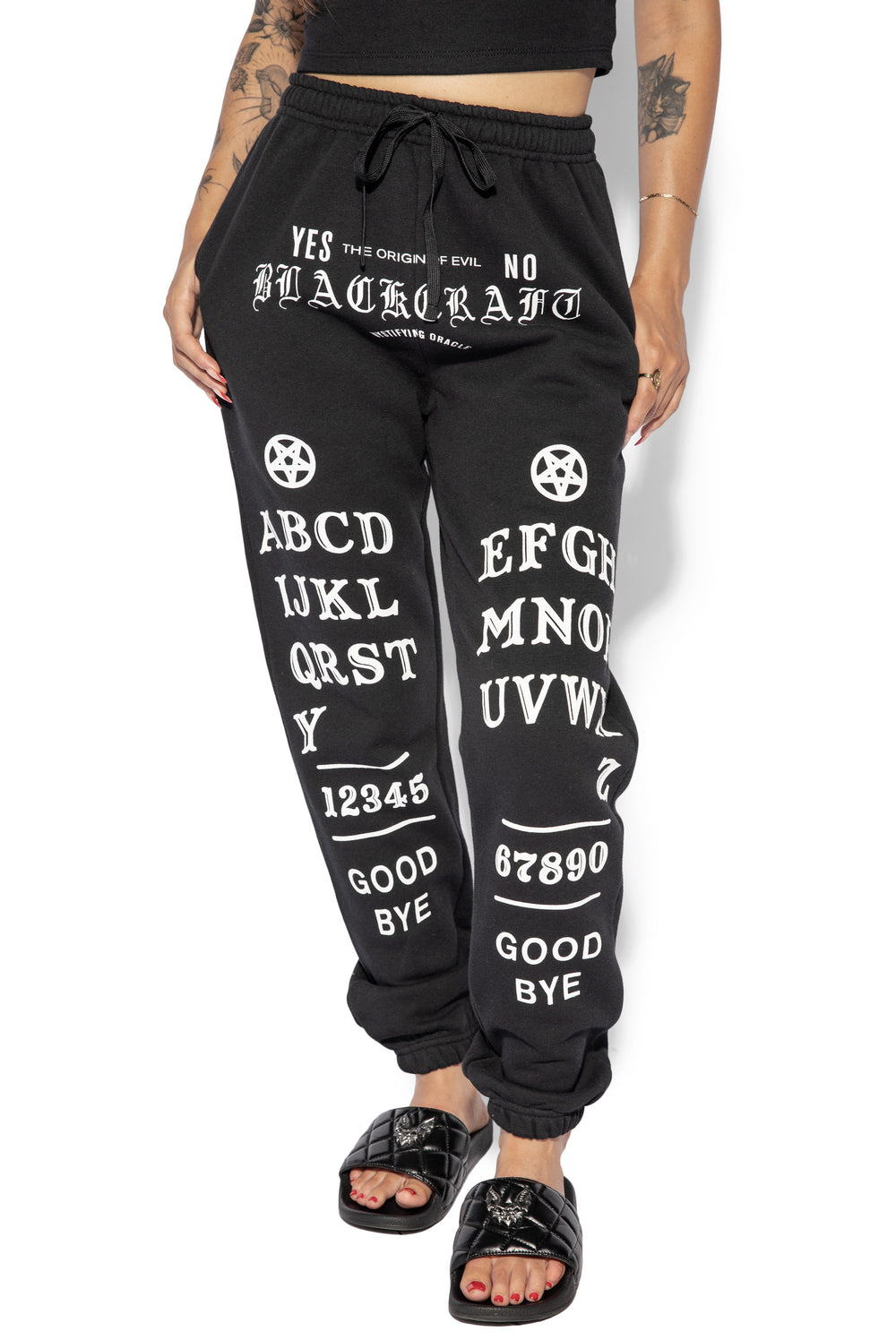 A model wearing a pair of classic fit black sweatpants with custom Blackcraft artwork along the front of each leg.
