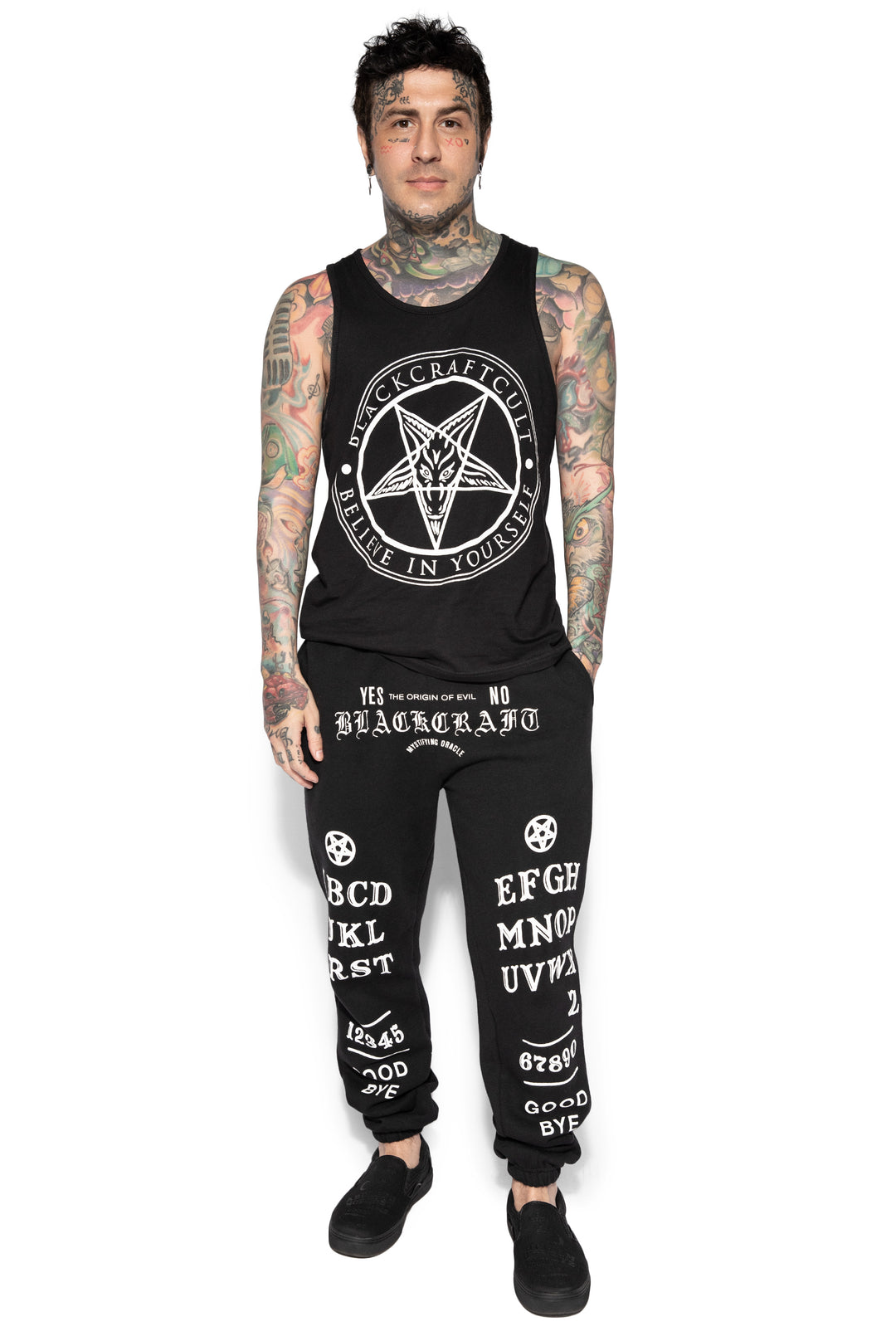 A model wearing a pair of classic fit black sweatpants with custom Blackcraft artwork along the front of each leg.