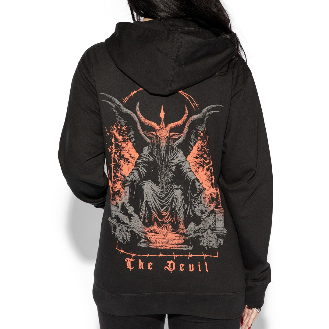 A brunette model wearing a classic black zip up hoodie with custom devil artwork on the front and back.