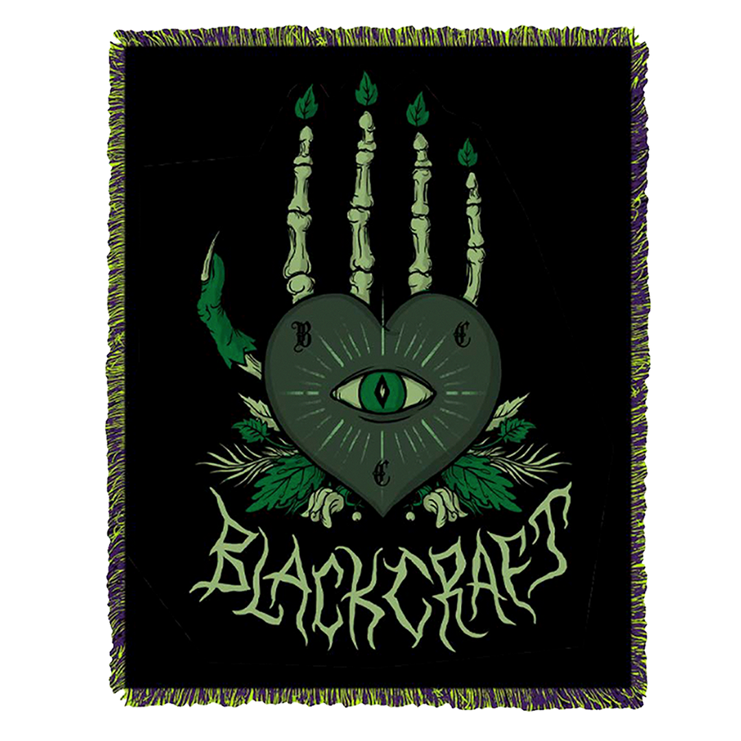 A large lightweight knit throw blanket with fringed trim and custom plant witch artwork, from Blackcraft.