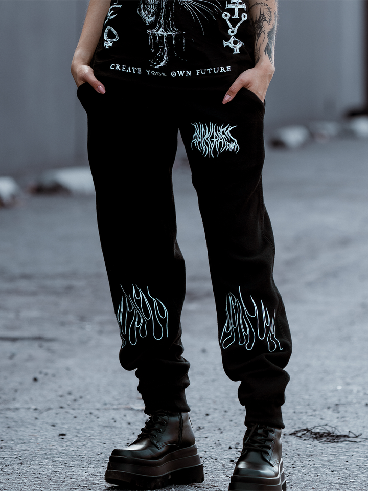 A model standing outside wearing classic black fleece unisex joggers with custom artwork from Blackcraft.
