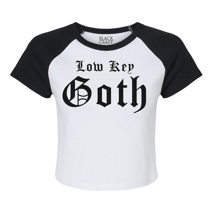 A stretchy raglan tee in white and black with Low Key Goth artwork on the front. 