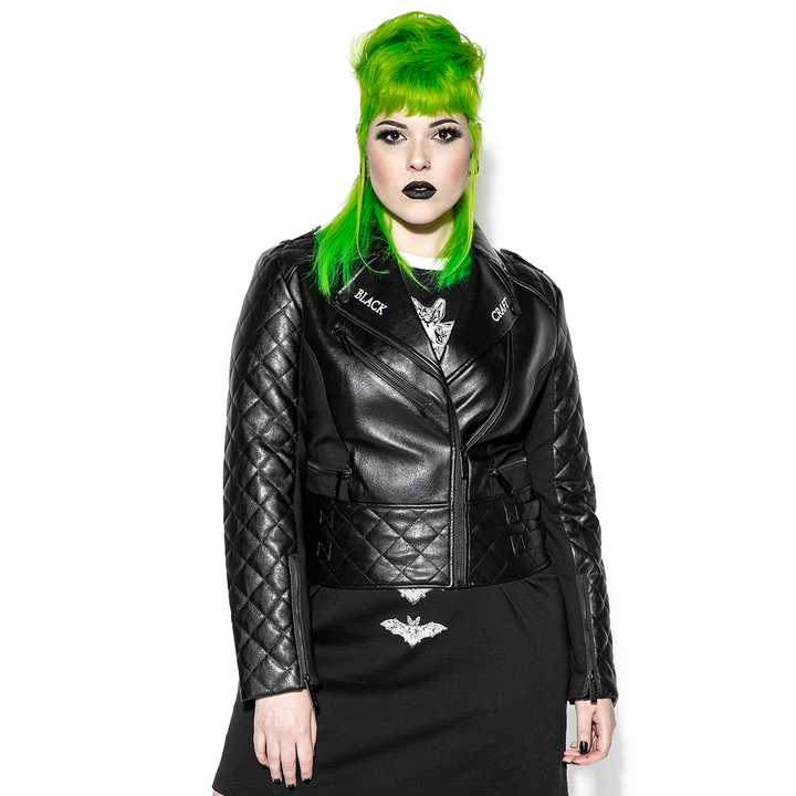 A green haired model wearing a classic black faux leather jacket from Blackcraft.