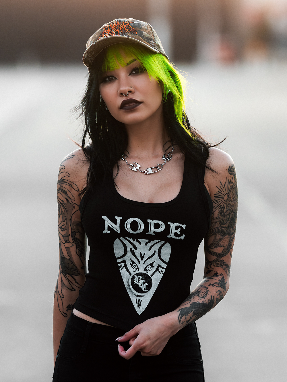 A model standing outside wearing a slim fit black tank top with Blackcraft Ouija artwork on the front.