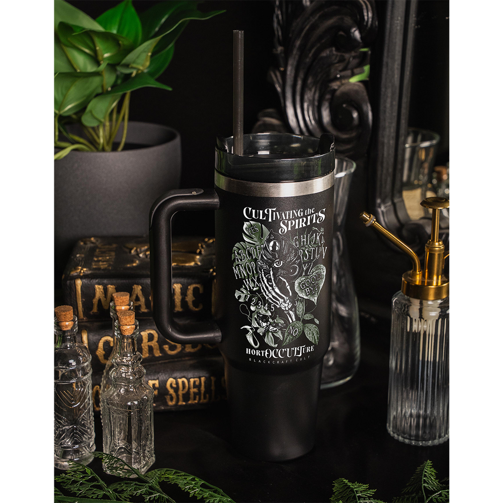 A large black travel tumbler with custom plant witch artwork on the front. From Blackcraft.