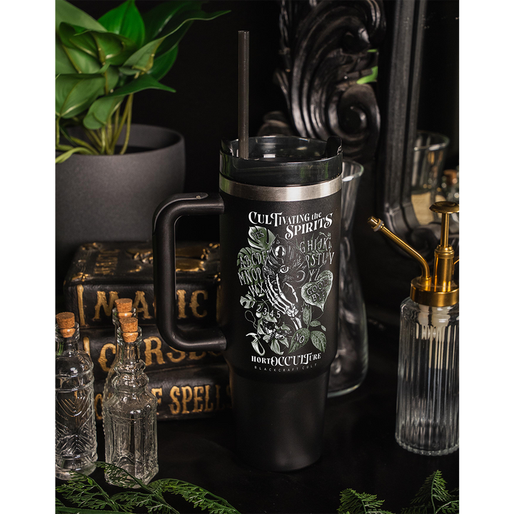 A large black travel tumbler with custom plant witch artwork on the front. From Blackcraft.