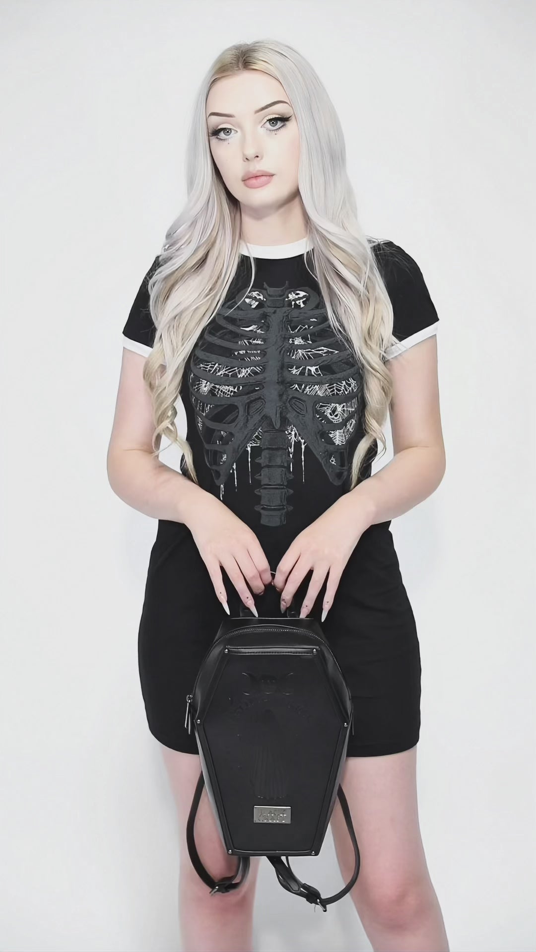 Black faux leather coffin shaped backpack with I Believe in Ghosts Stories art embossed on front.