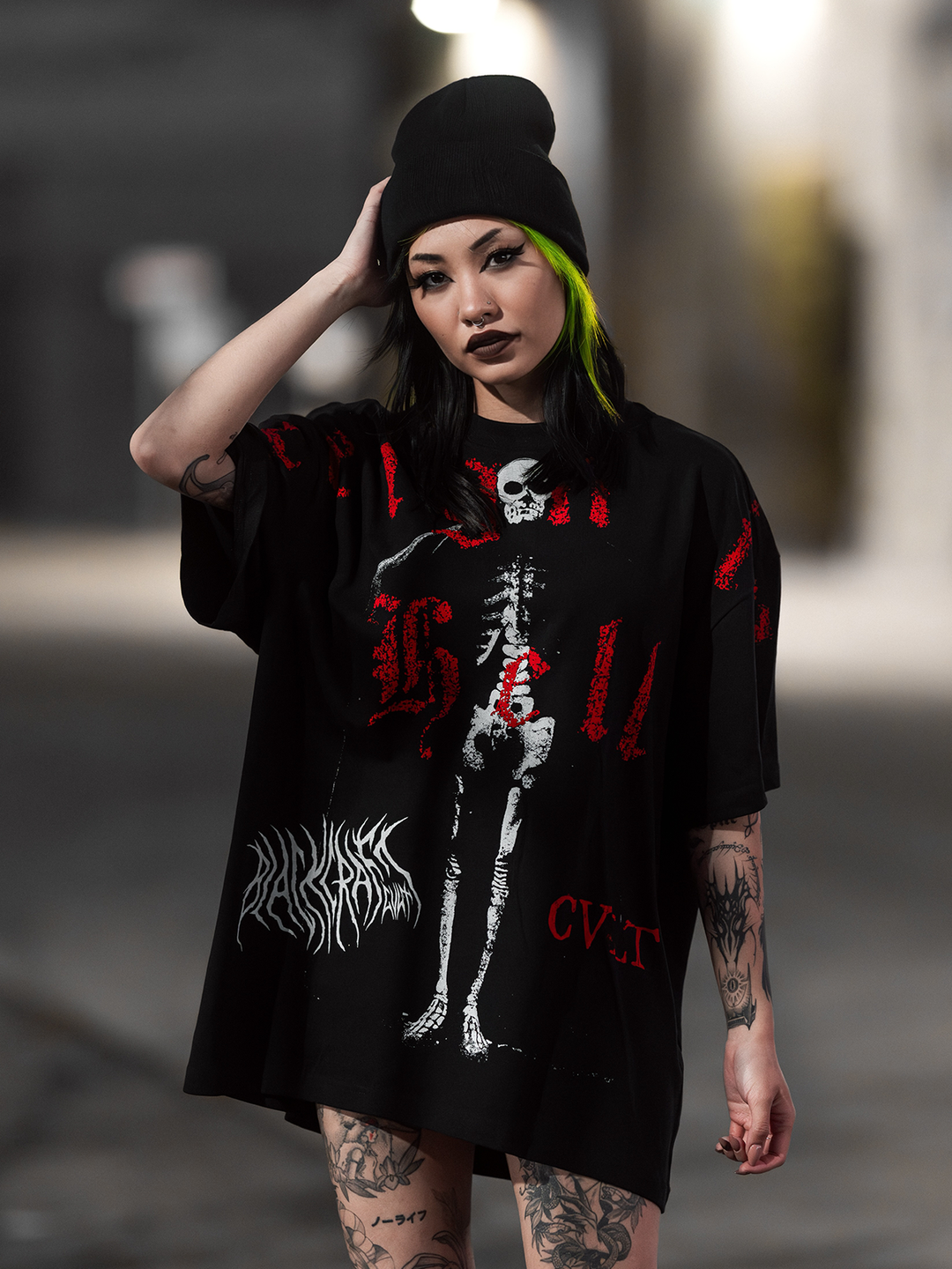 A model standing outside wearing an oversized black tee with custom Blackcraft artwork on the front. 