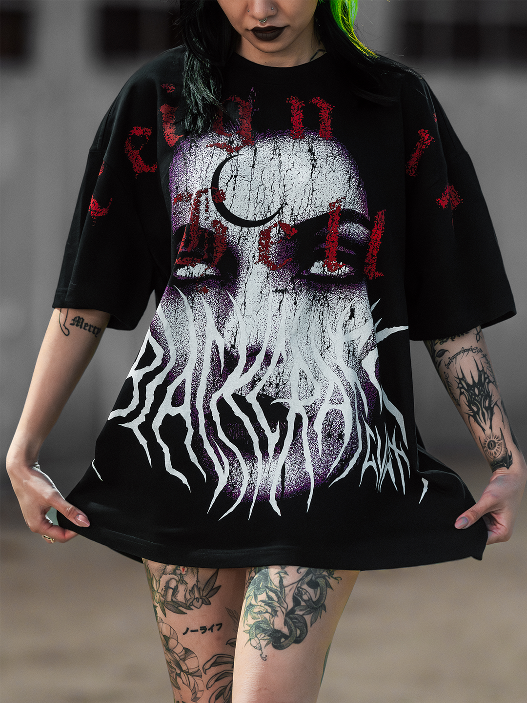 A model standing outside wearing an oversized black tee with custom Blackcraft artwork on the front. 