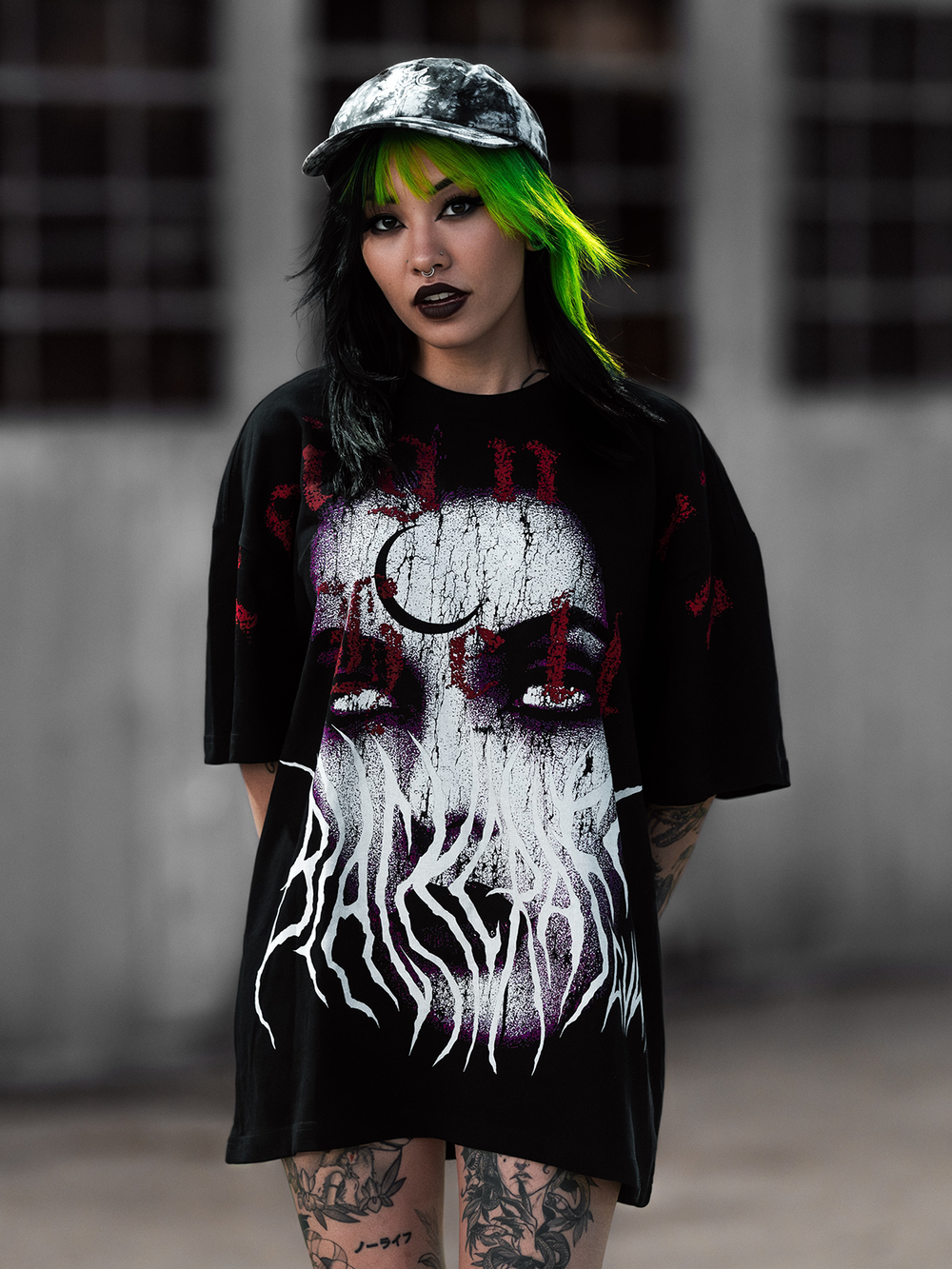 A model standing outside wearing an oversized black tee with custom Blackcraft artwork on the front. 