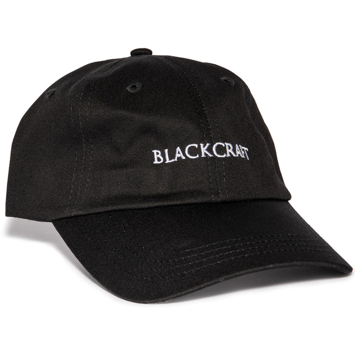 A black washed cotton dad hat with embroidered Blackcraft logo on the front.