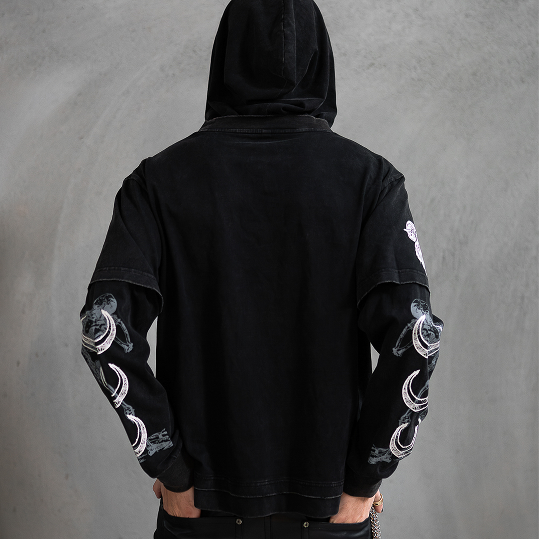 A model wearing a washed black long sleeve twofer pullover hoodie with custom Blackcraft artwork on the front and along the sleeves.