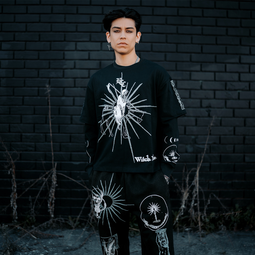 A model standing outside wearing a layered effect twofer long sleeve tee with custom Blackcraft artwork on the front and along the sleeves. 