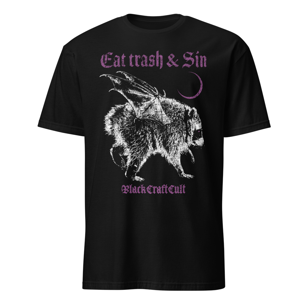 A black short-sleeve t-shirt with a gothic-style graphic print featuring a white raccoon with wings and the text 'Eat trash & Sin' and 'Black Craft Cult' in purple.