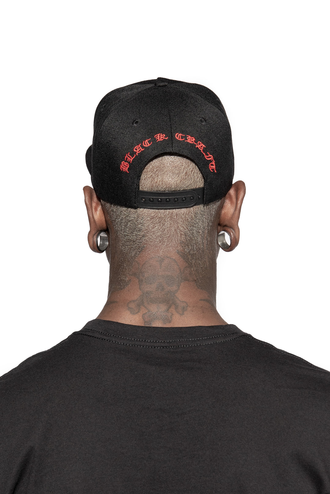 A model wearing a black snapback hat with red embroidered 666 on the front. 