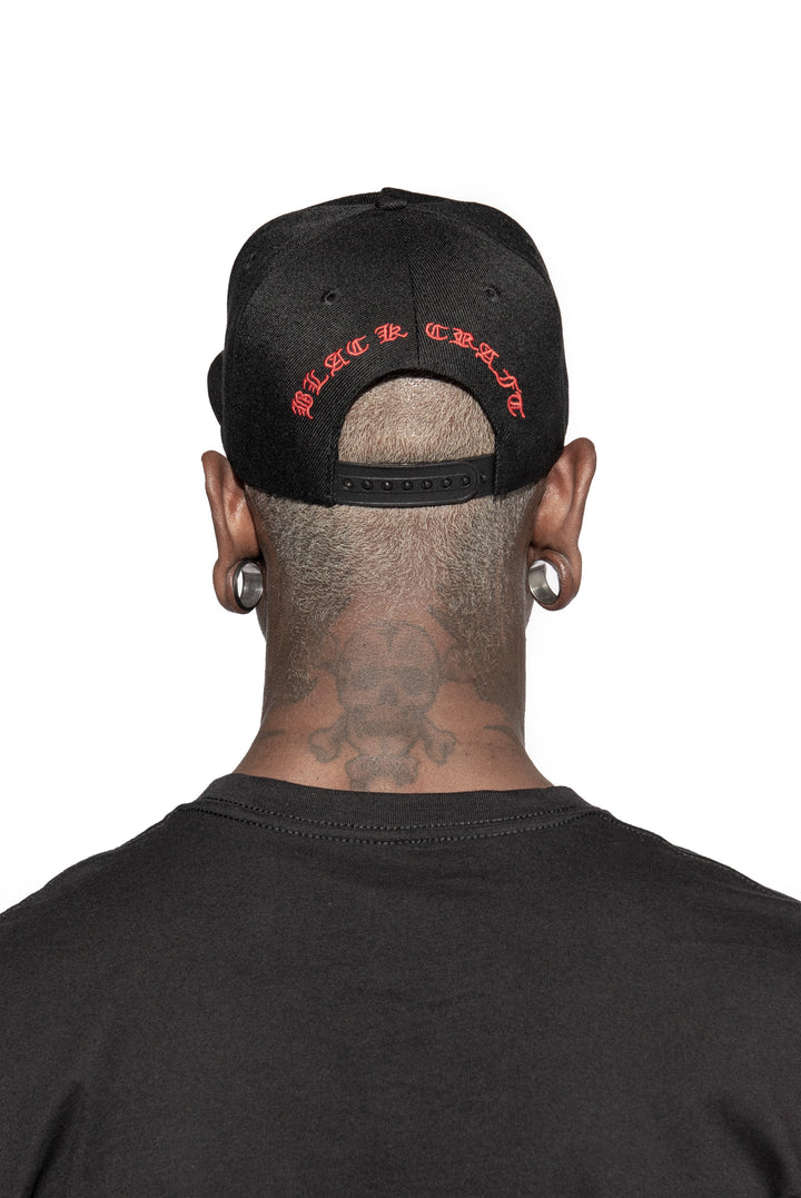 A model wearing a black snapback hat with red embroidered 666 on the front. 