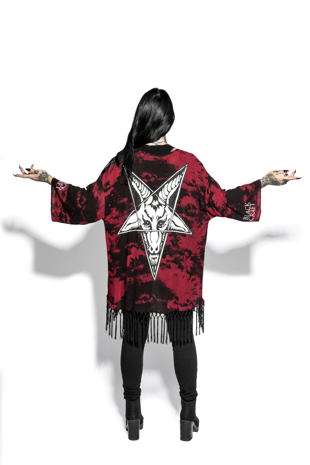 A gothic kimono cover up with fringed trim, and open front, and kimono half length sleeves.