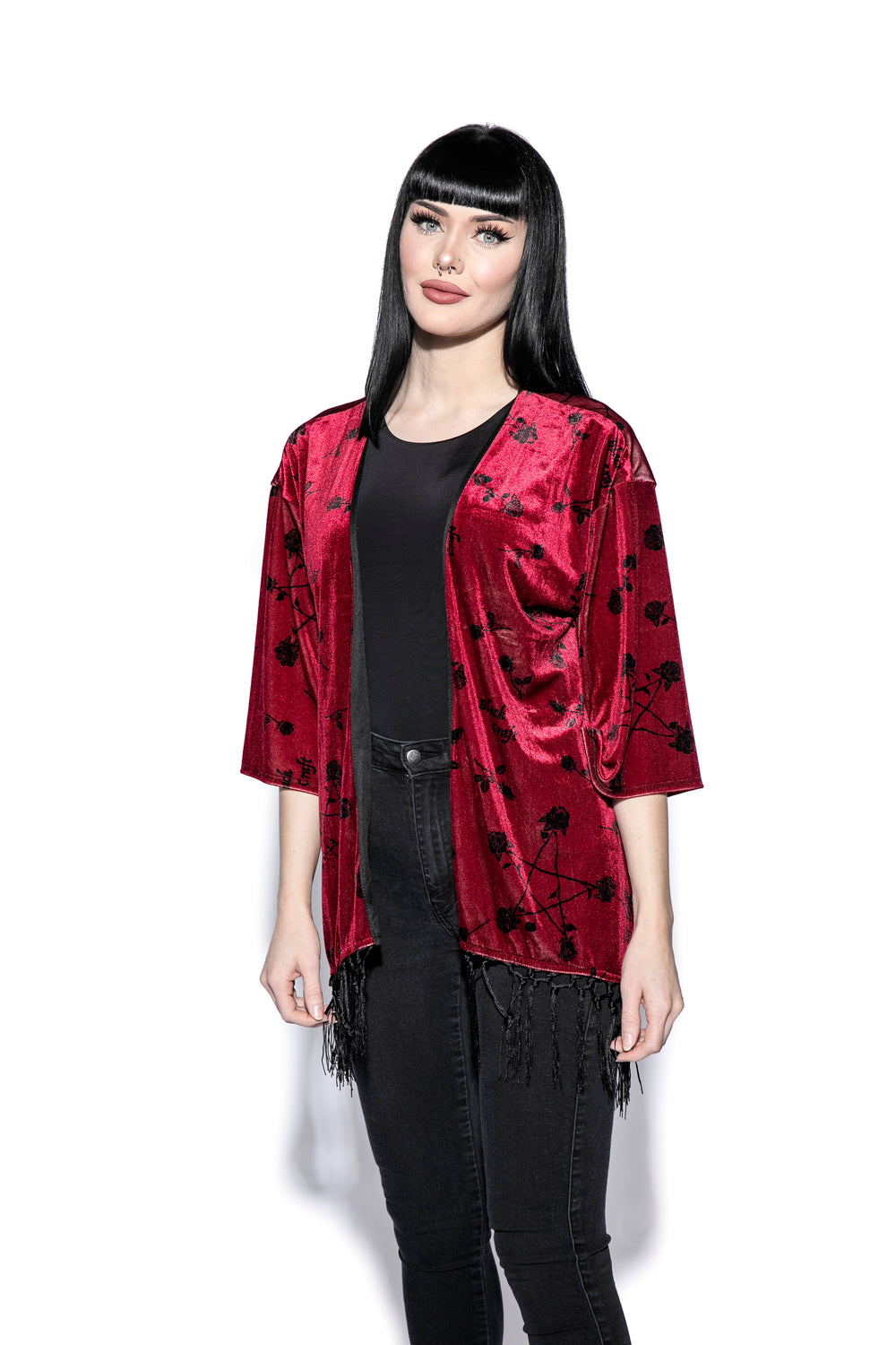 A gothic velvet kimono cover up with fringed trim, an open front, and kimono half length sleeves.