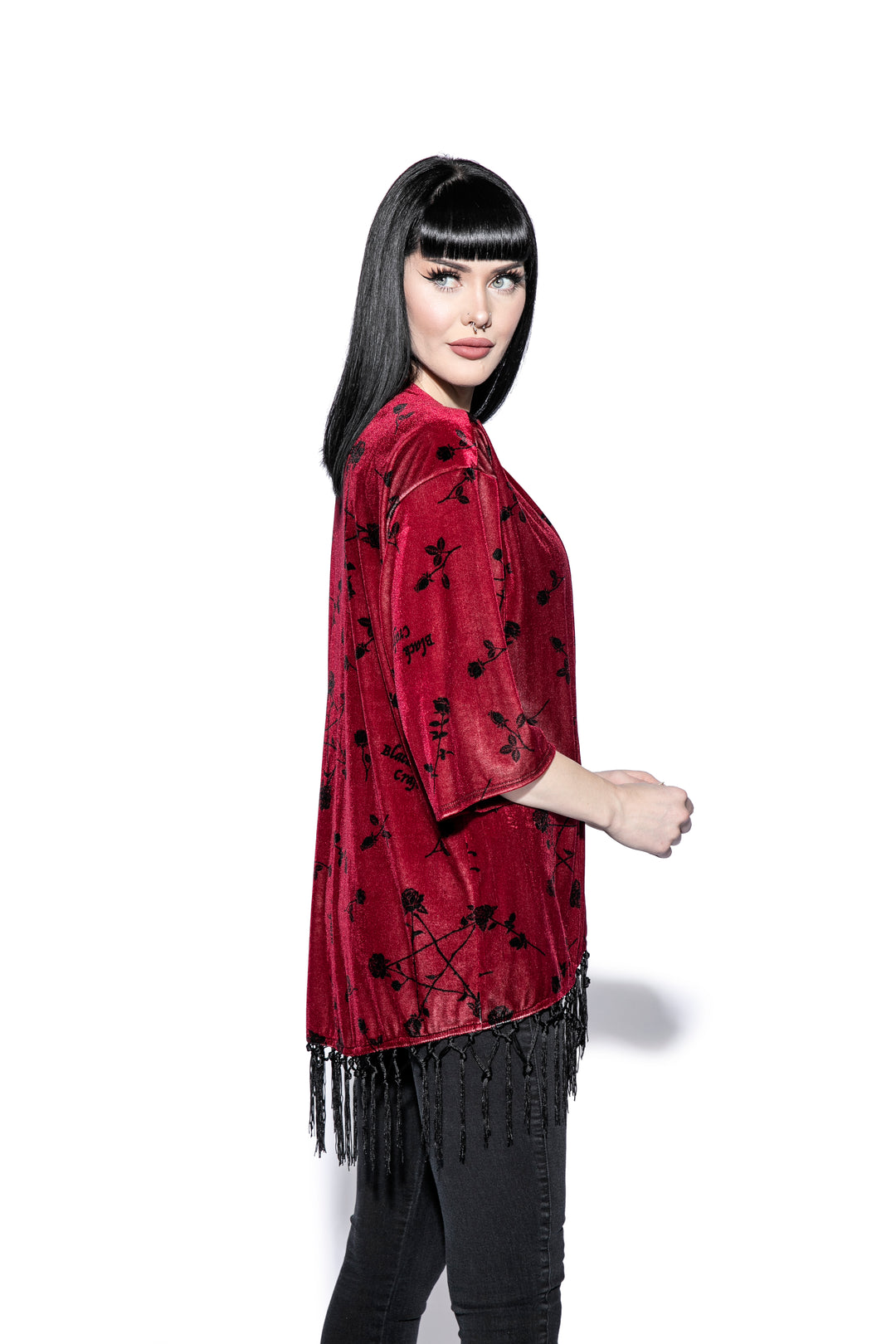 A gothic velvet kimono cover up with fringed trim, an open front, and kimono half length sleeves.