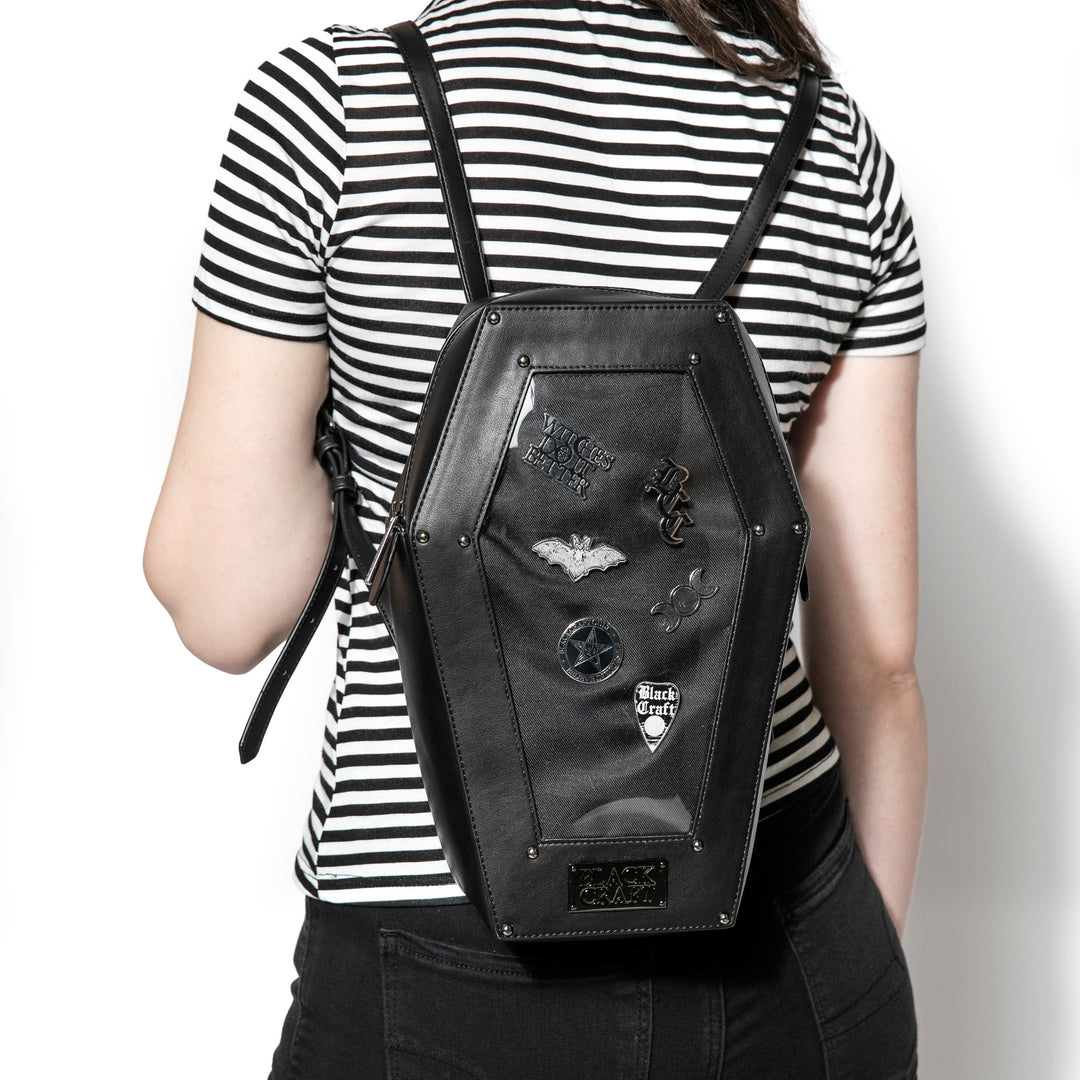 Black faux leather coffin shaped backpack with a Pin Collecting Window. 