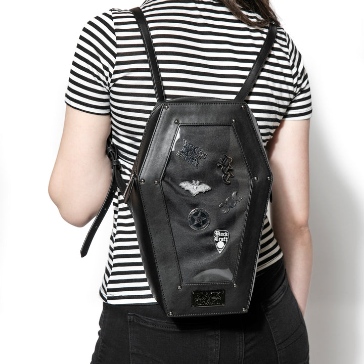 Black faux leather coffin shaped backpack with a Pin Collecting Window. 