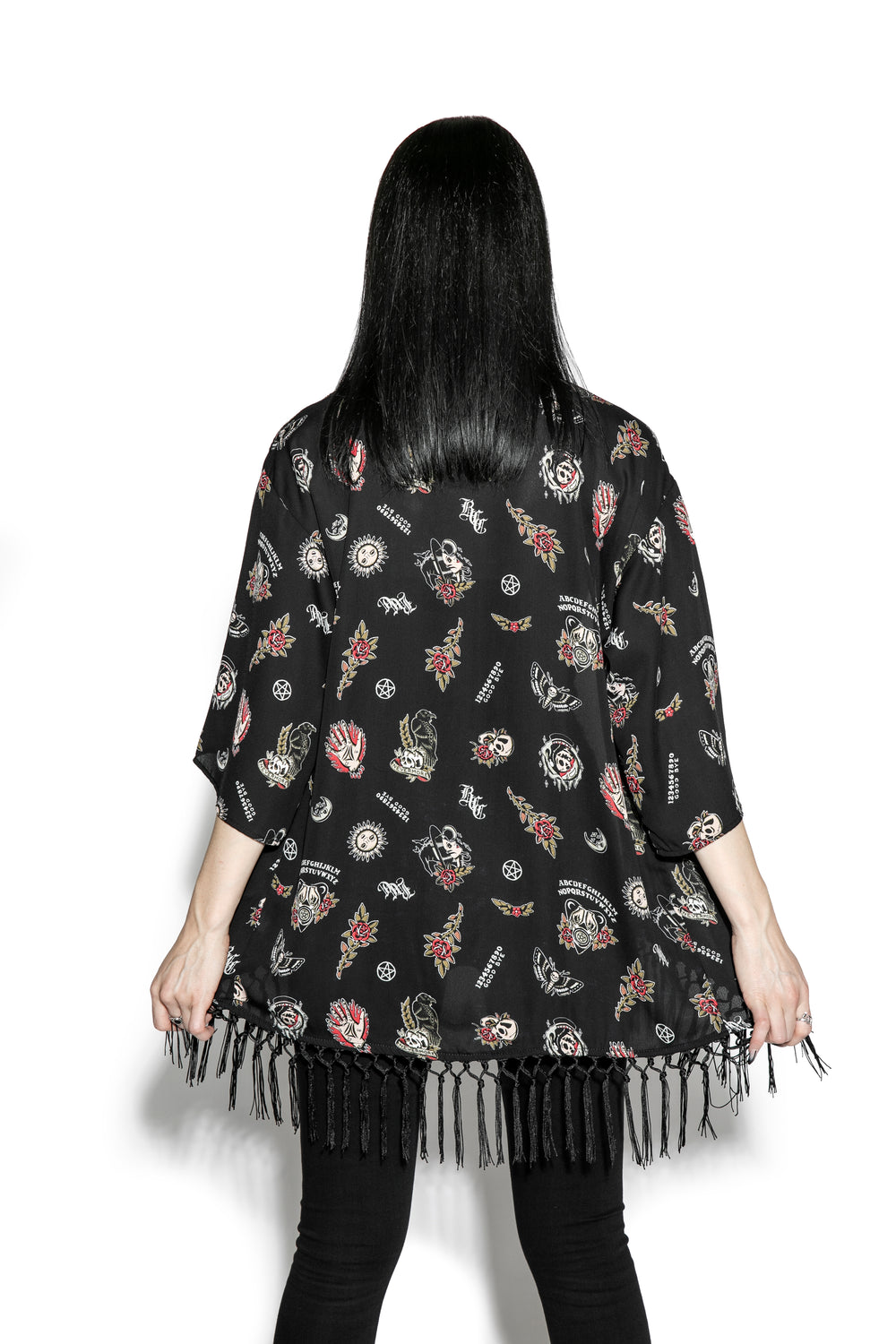 A gothic kimono cover up with fringed trim, and open front, and kimono half length sleeves.