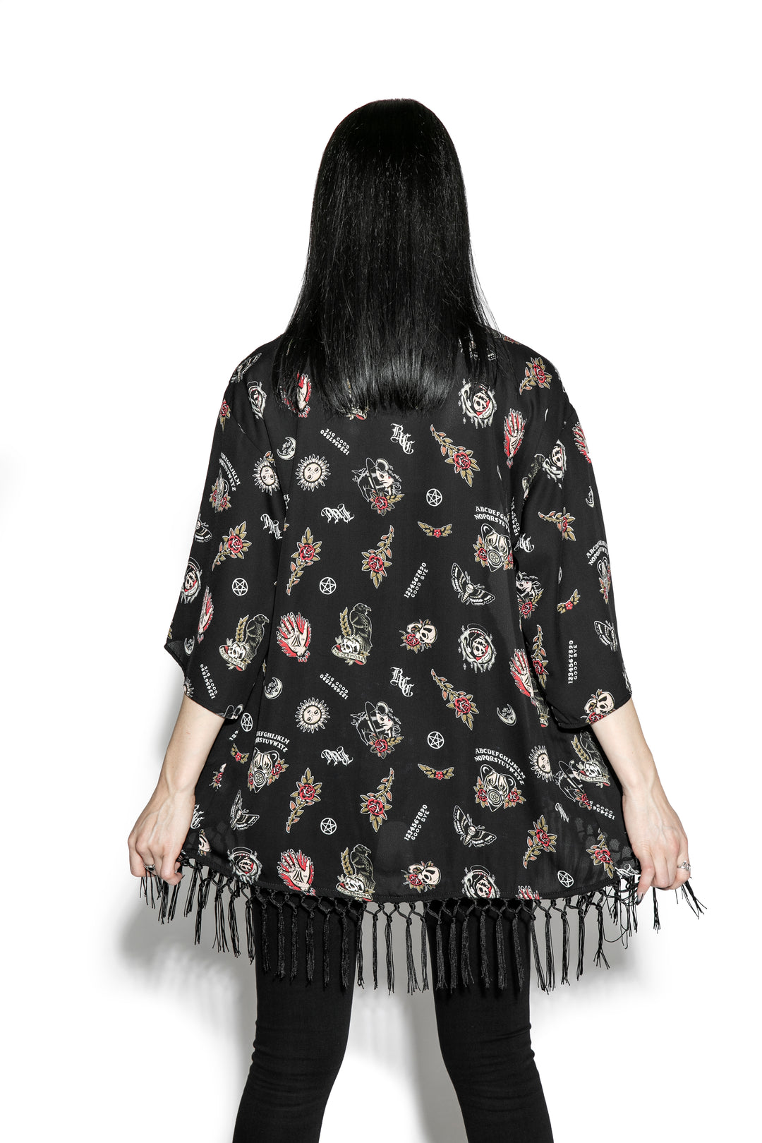 A gothic kimono cover up with fringed trim, and open front, and kimono half length sleeves.