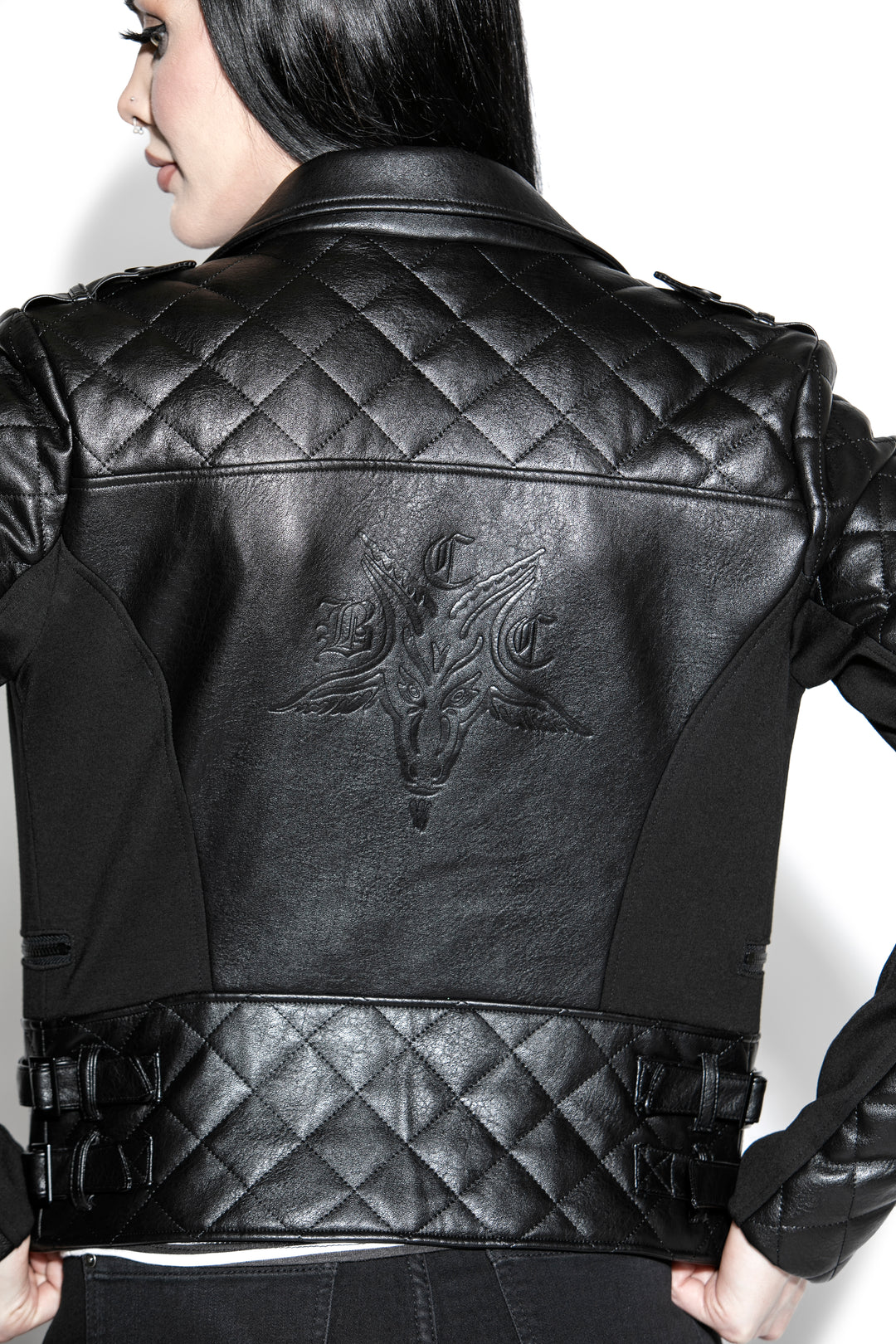 A black haired model wearing a classic black faux leather jacket from Blackcraft.