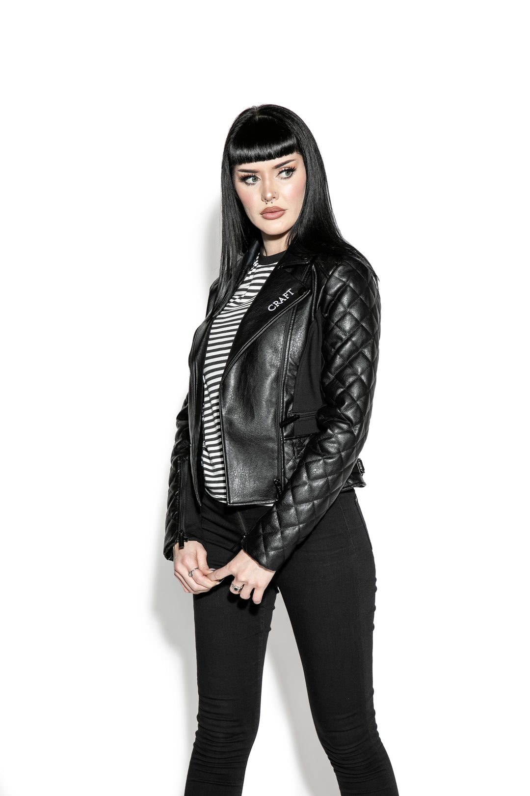 A black haired model wearing a classic black faux leather jacket from Blackcraft.