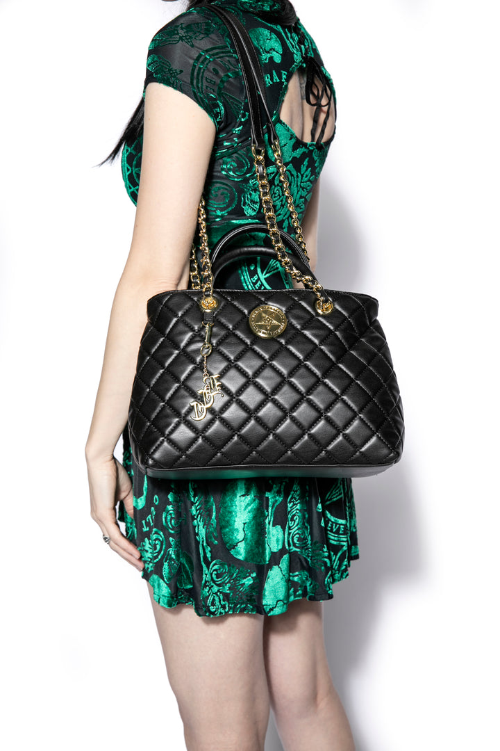 Black quilted satchel with magnetic closure. 