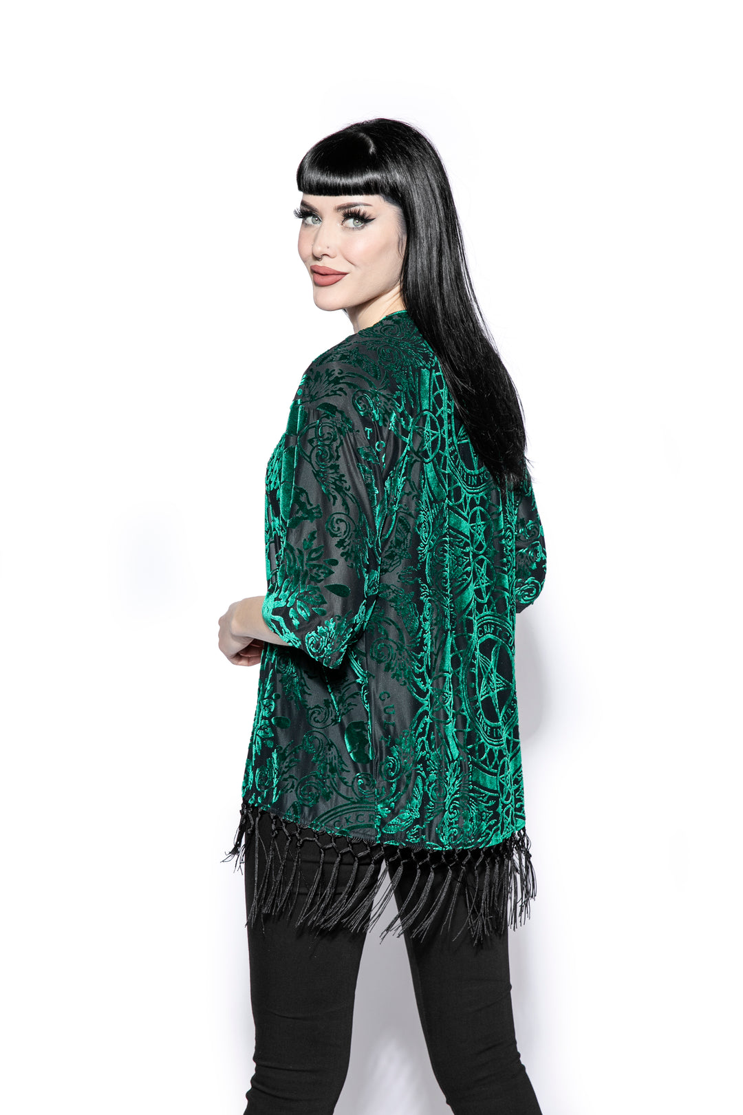 A gothic velvet kimono cover up with fringed trim, an open front, and kimono half length sleeves.