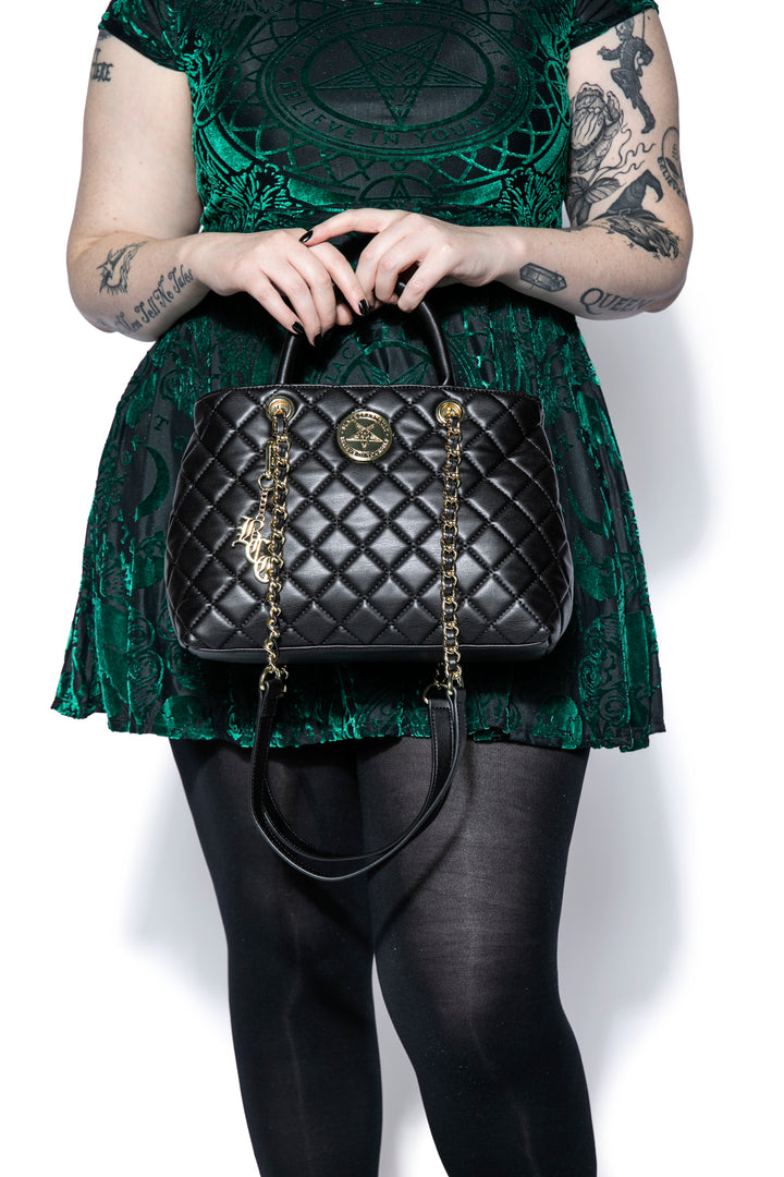 Black quilted satchel with magnetic closure. 