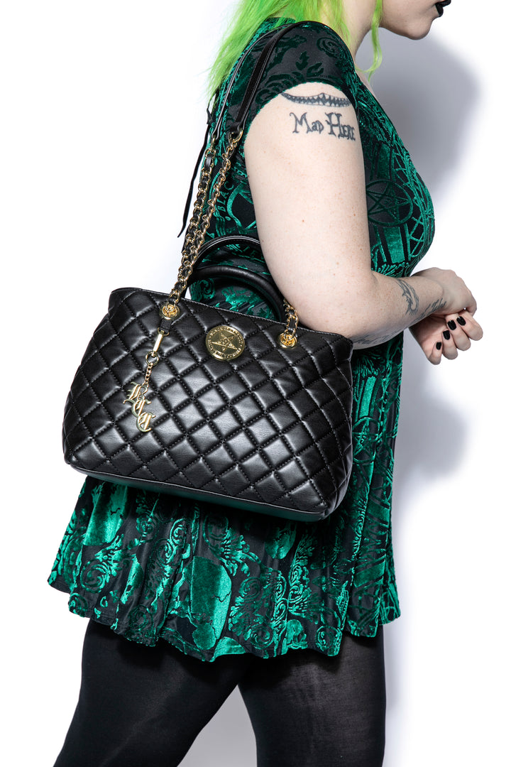 Black quilted satchel with magnetic closure. 