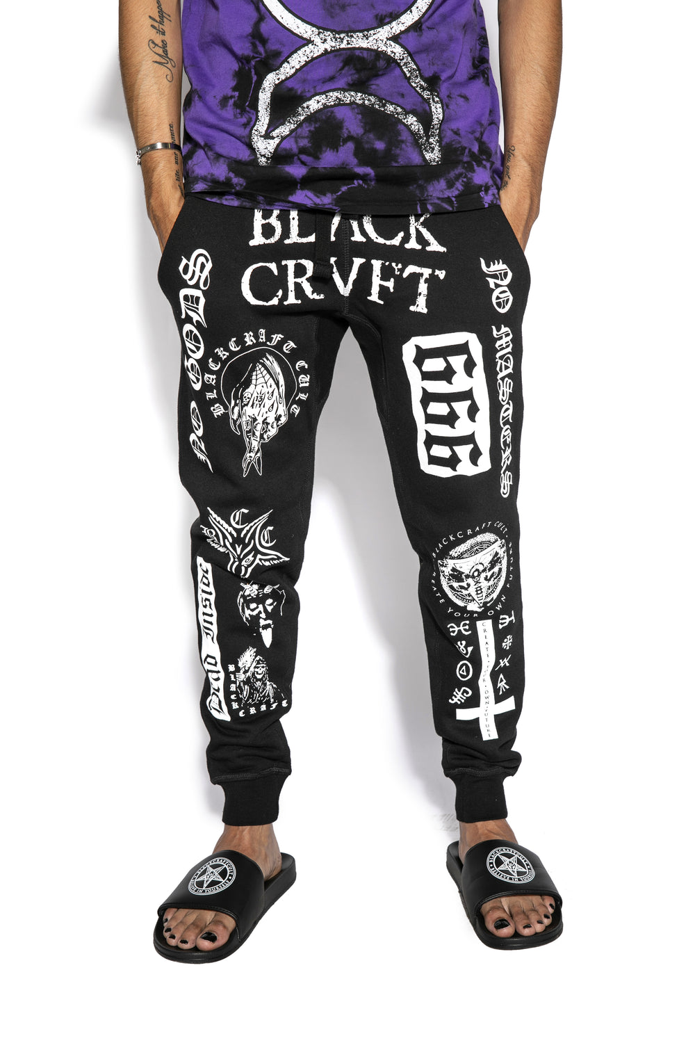 A model wearing a pair of classic fit black joggers with custom Blackcraft artwork along the front of each leg.