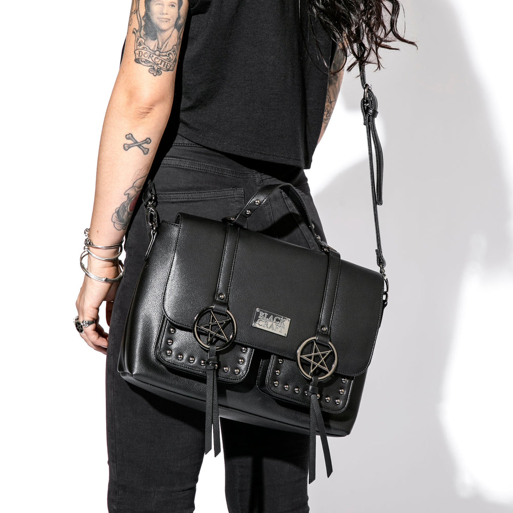 Black faux leather messenger bag with gunmetal finish pentagrams and Blackcraft logo plaque. 