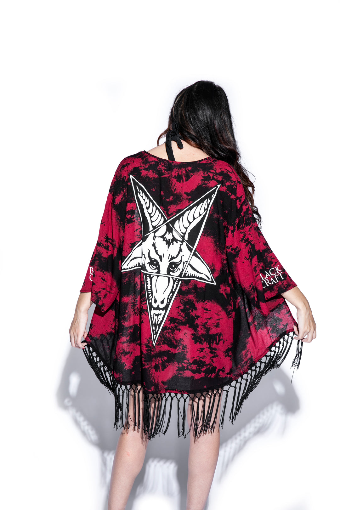 A gothic kimono cover up with fringed trim, and open front, and kimono half length sleeves.