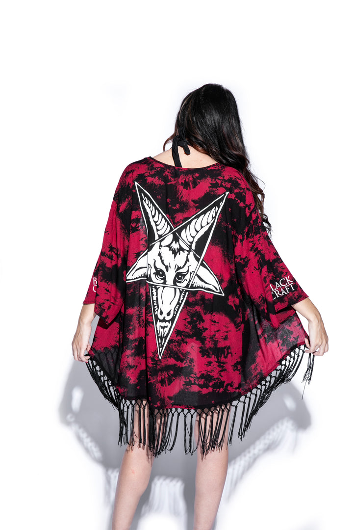 A gothic kimono cover up with fringed trim, and open front, and kimono half length sleeves.