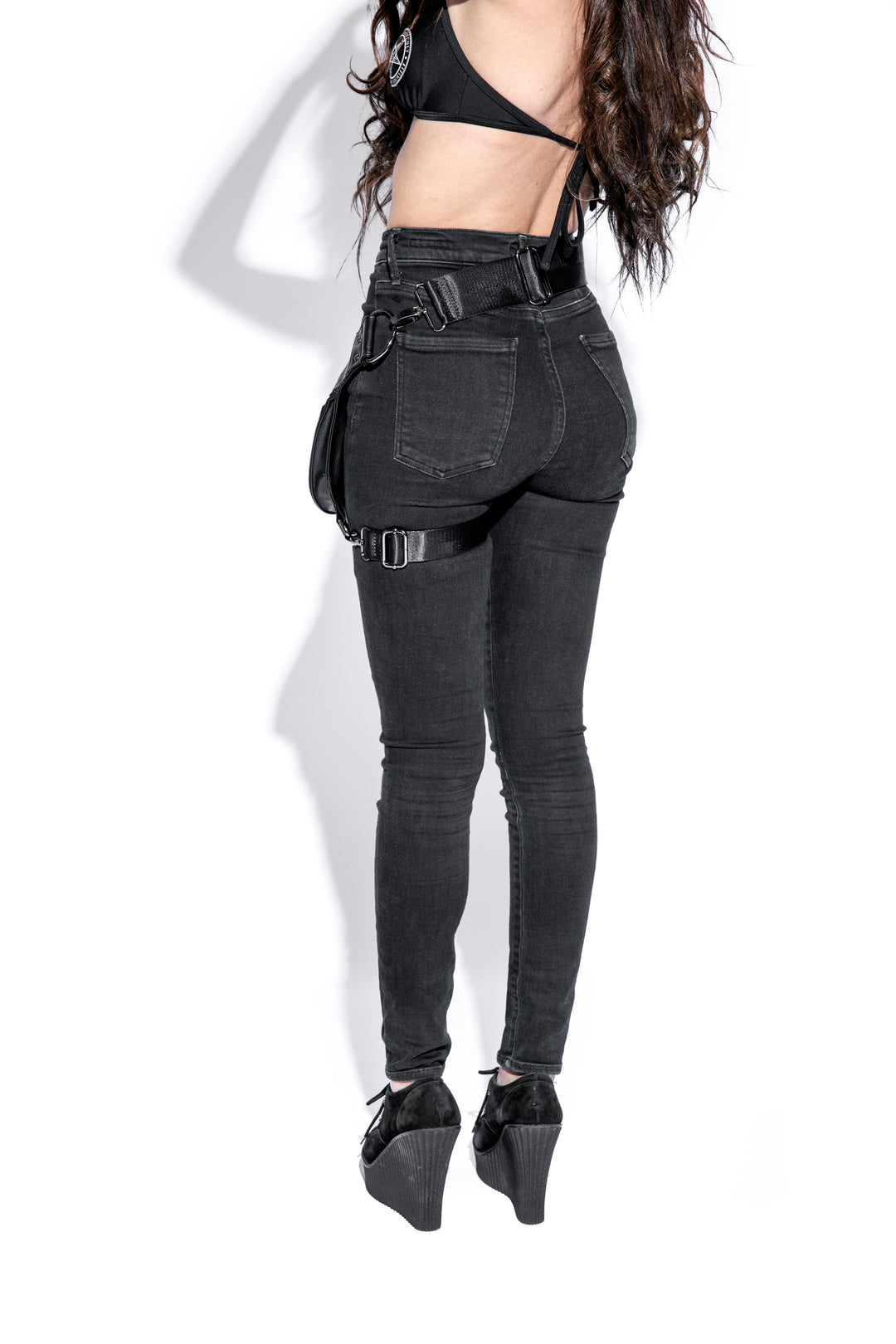 Black faux leather hip bag with Believe in Yourself logo embossed on front. 