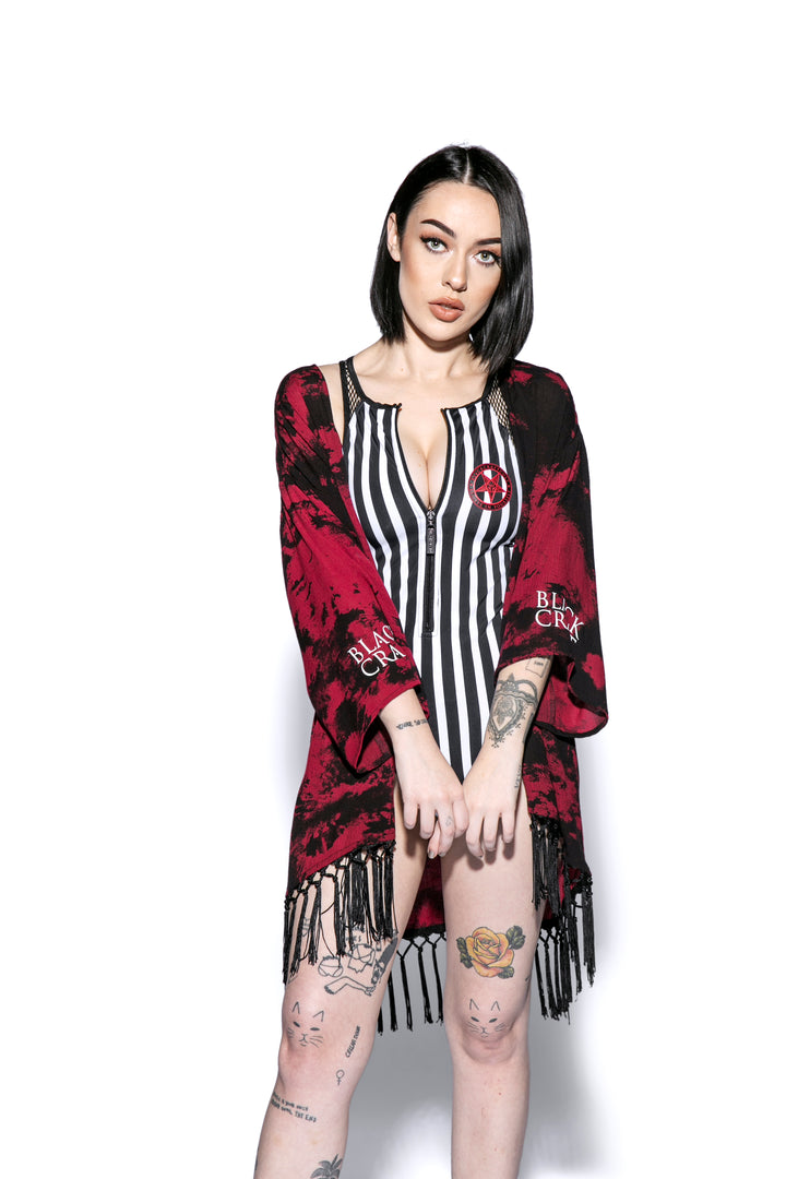 A gothic kimono cover up with fringed trim, and open front, and kimono half length sleeves.