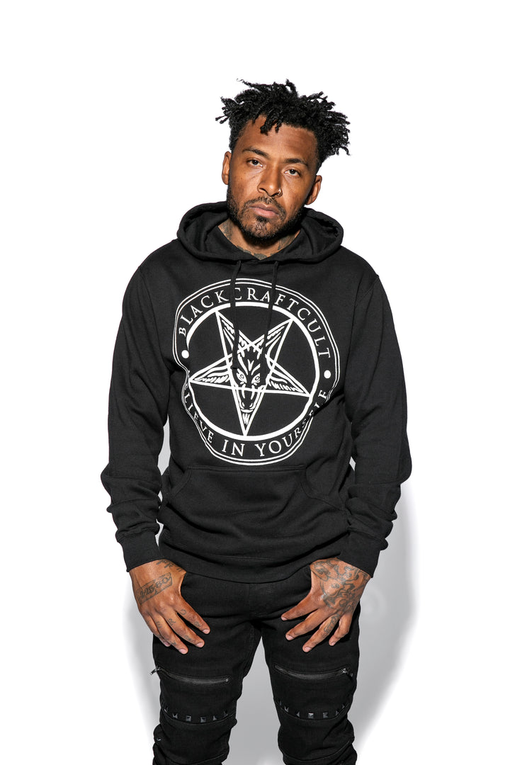 A model wearing a classic black pullover hoodie with custom Blackcraft artwork on the front. 