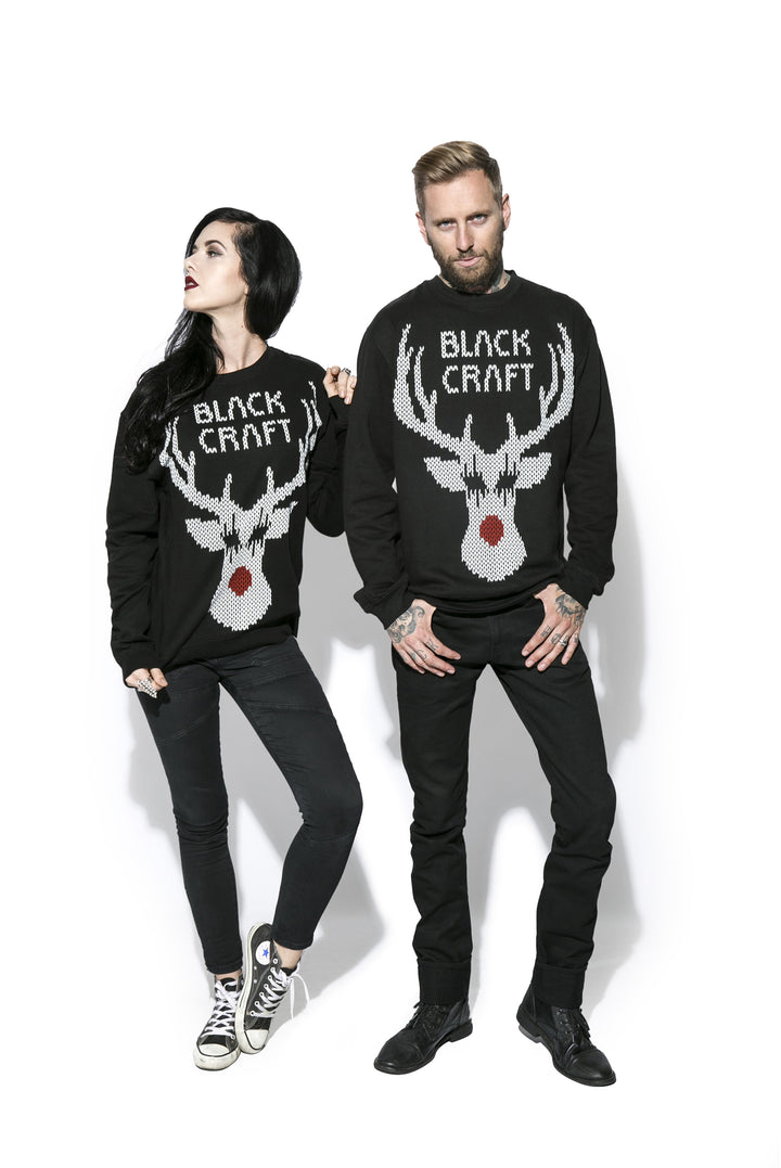 Two models wearing a black sweatshirt with the Blackcraft logo and a reindeer on the front and text on the back. 